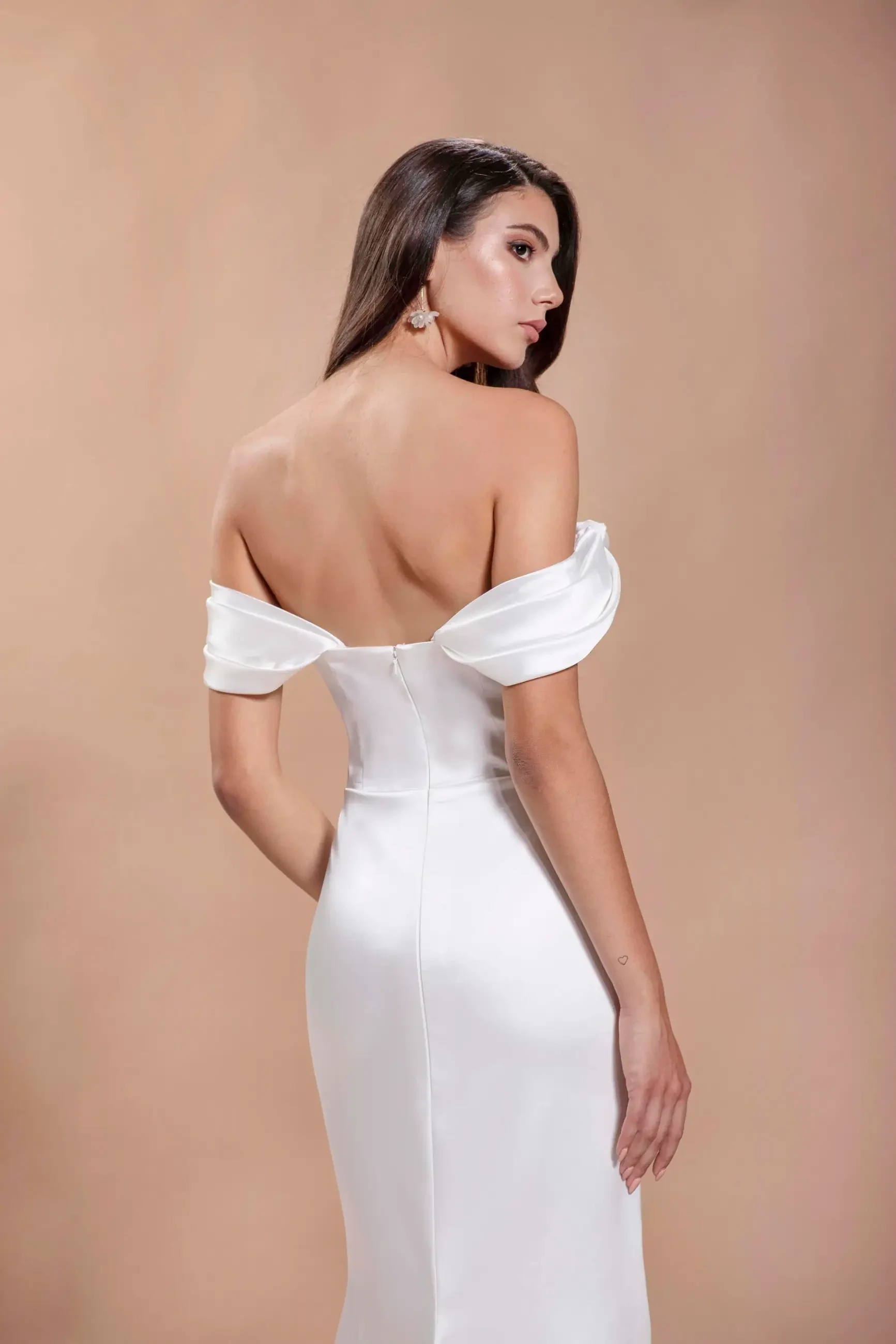 model is wearing an off the shoulder satin bridal gown