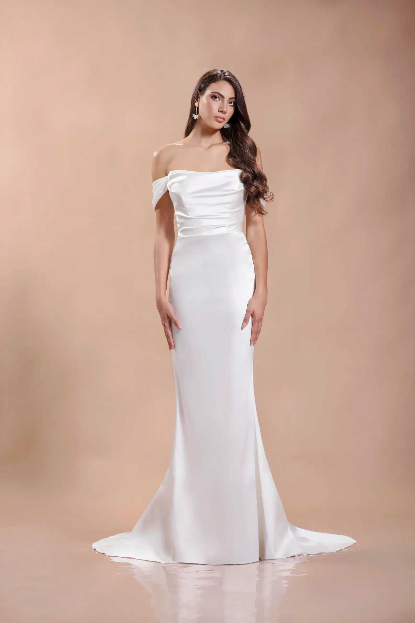 model is wearing an off the shoulder satin bridal gown