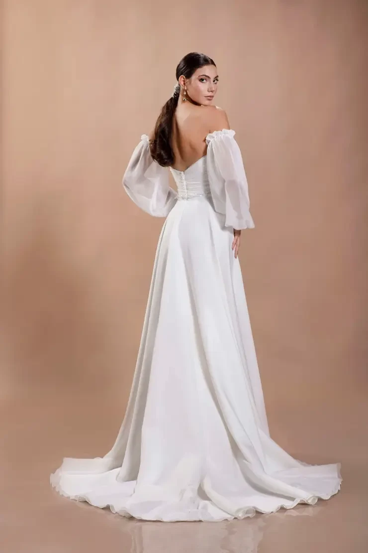 model is wearing an off the shoulder a-line chiffon bridal gown