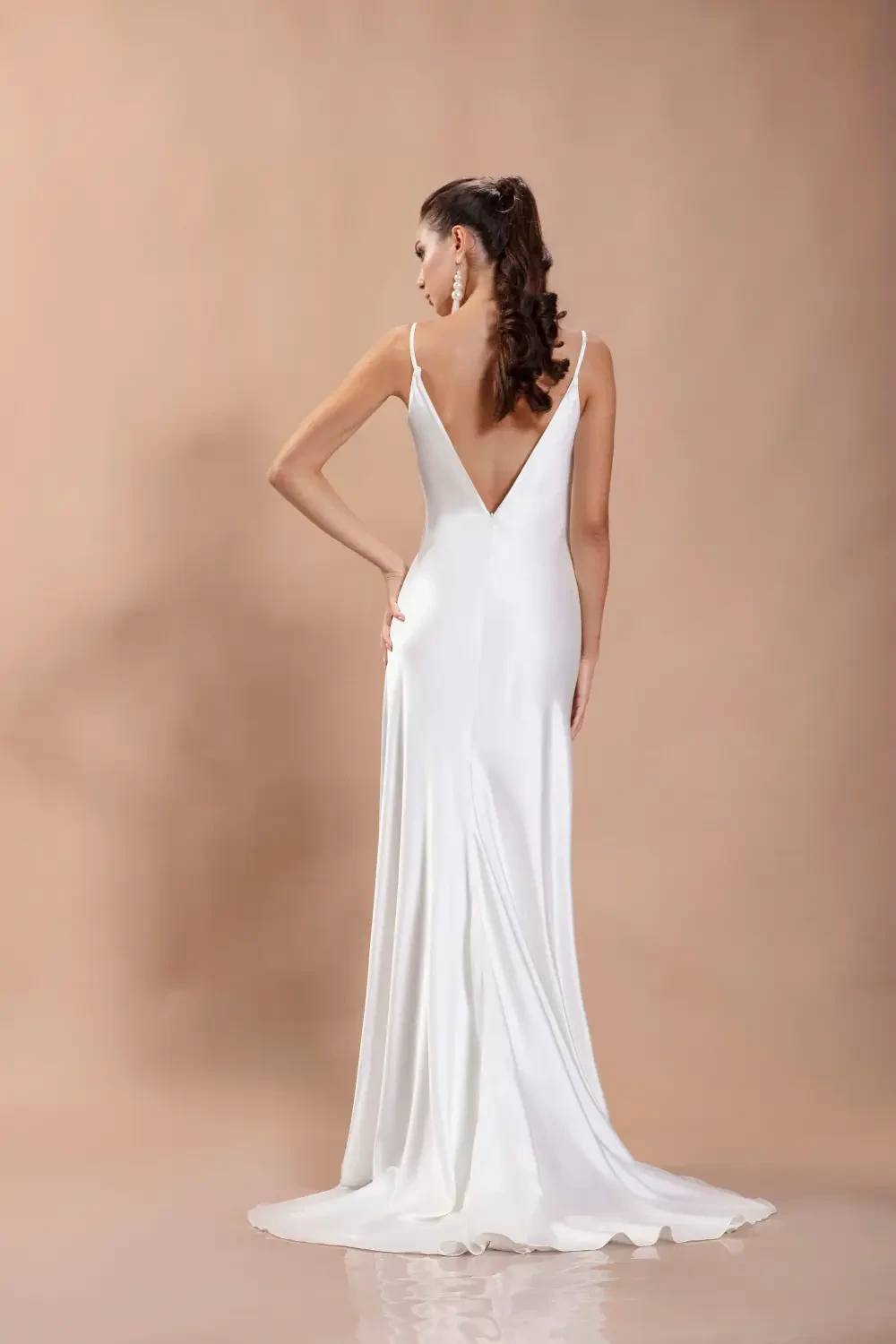 model is wearing a sleeveless silky bridal gown