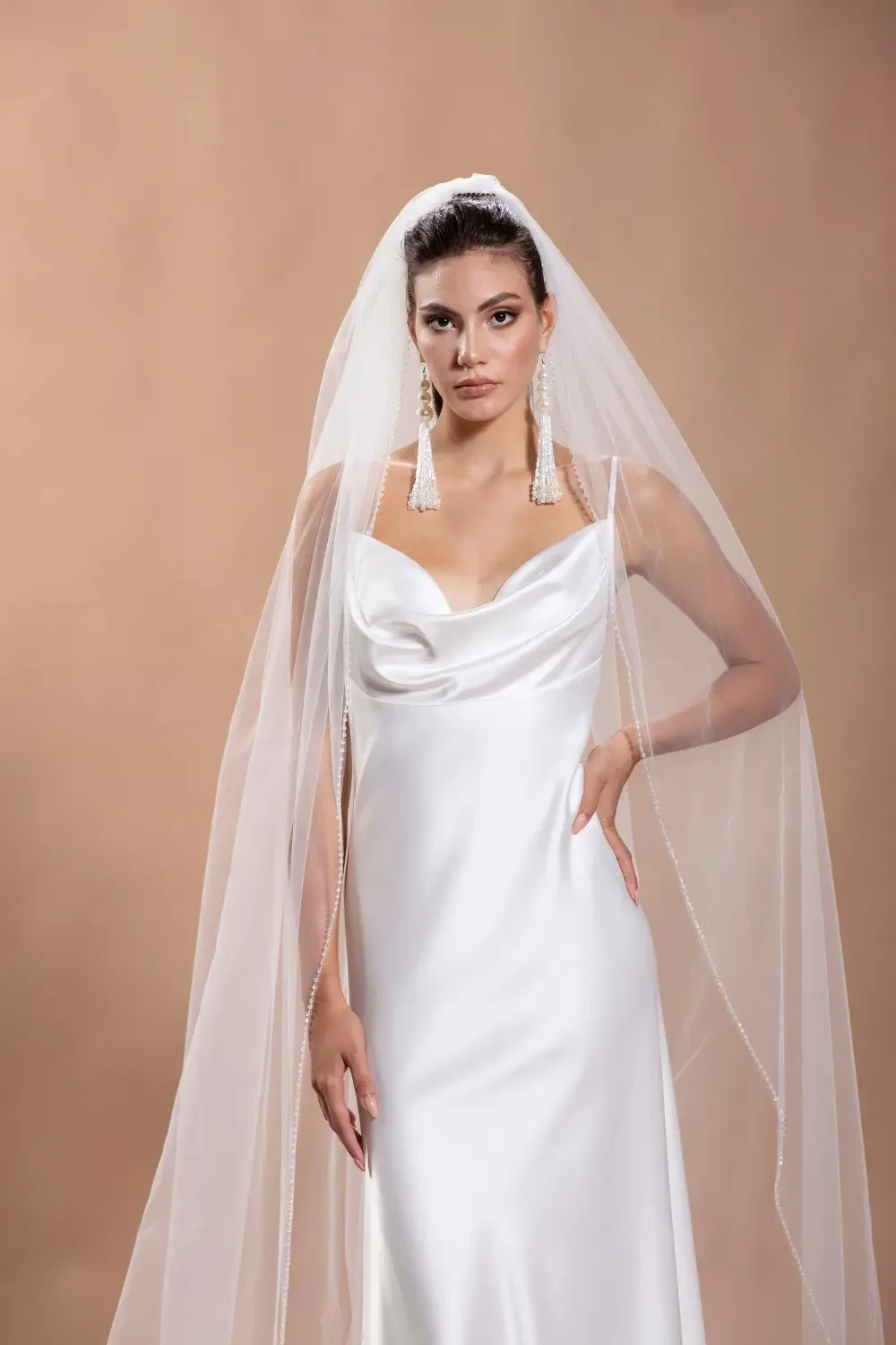 model is wearing a sleeveless silky bridal gown