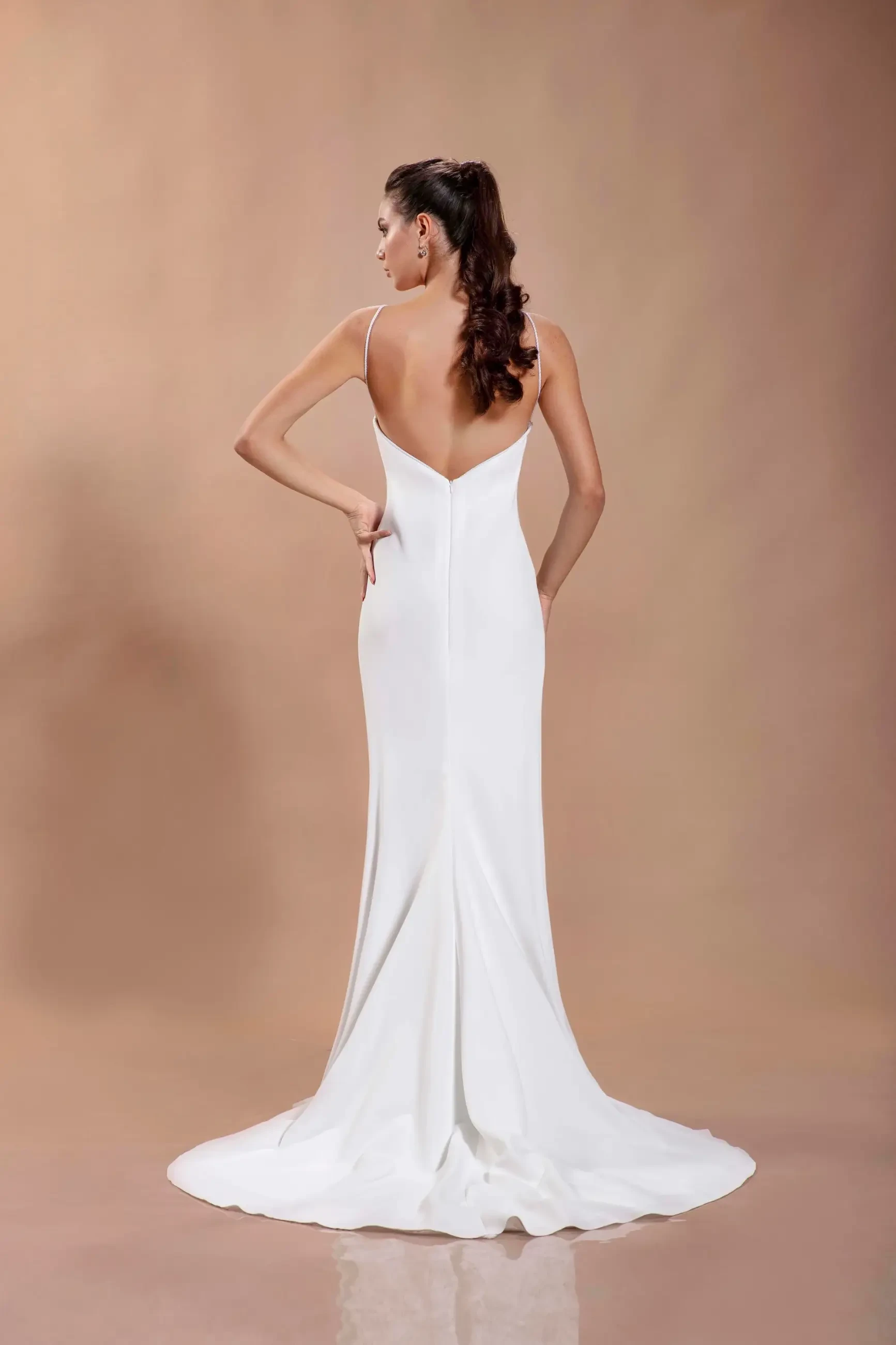 model is wearing a crepe sleeveless spaghetti strap wedding dress