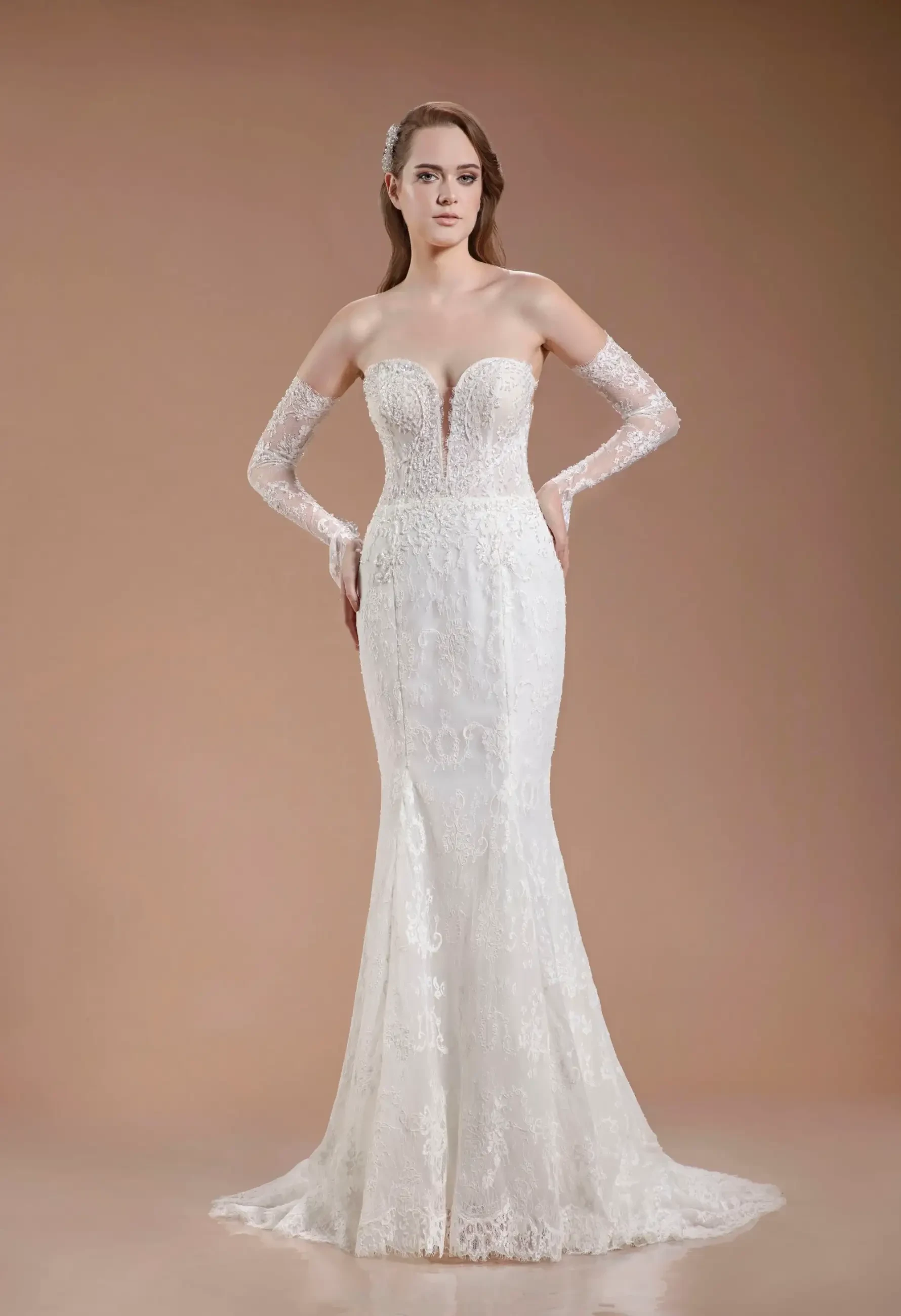 Model is wearing a strapless gown with off-the-shoulder lace gauntlet sleeves, a plunging corset bodice, illusion back panels, and a sweeping train.