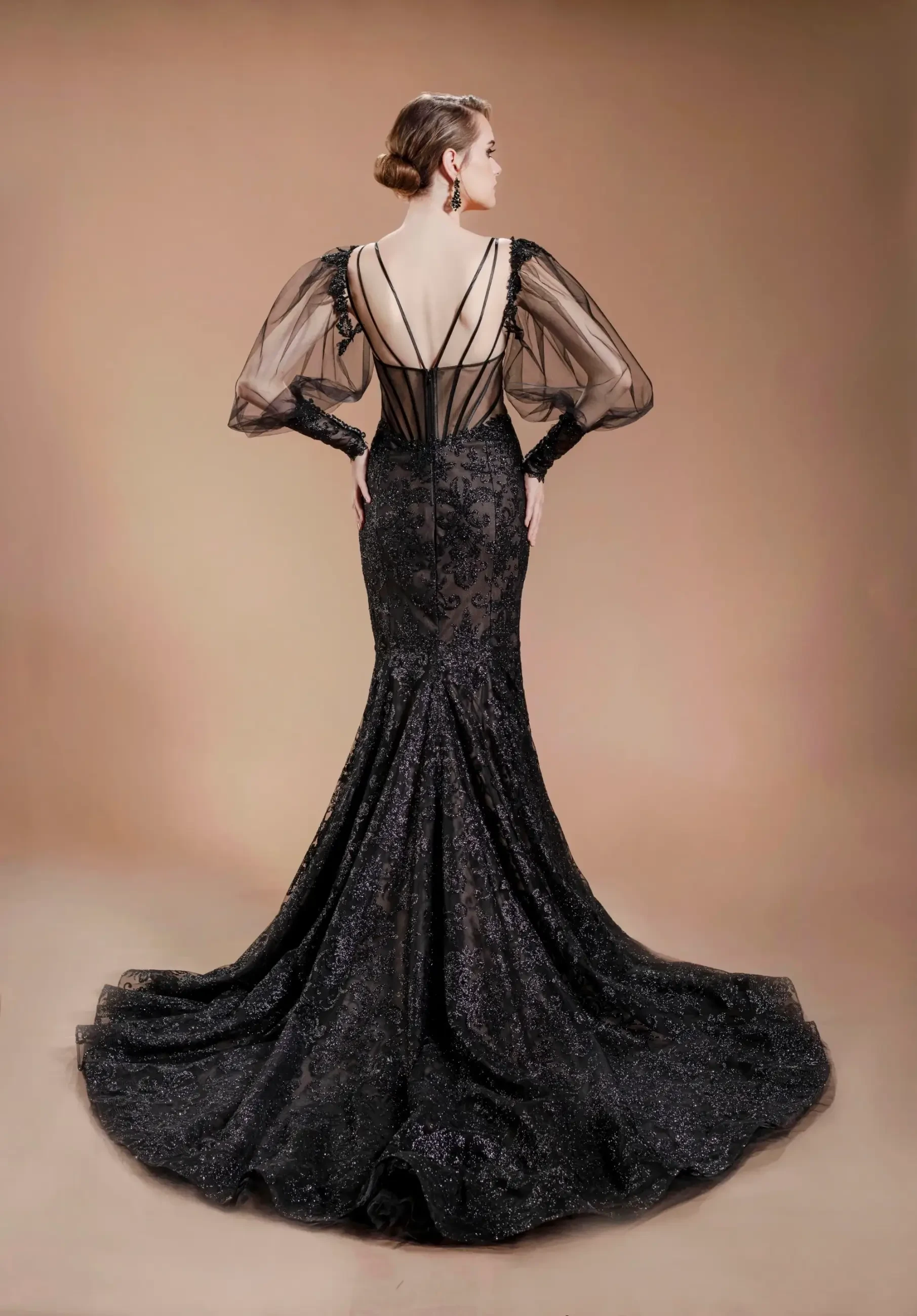 model is wearing a black mermaid long sleeve wedding dress